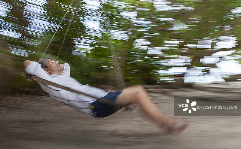 在热带海滩上摇摆的年长男人，动态模糊图片素材