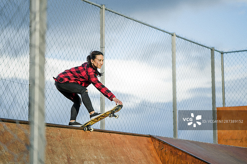 在公园坡道顶端的滑板女图片素材