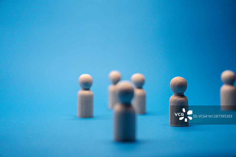 蓝色背景上的木制小人图片素材