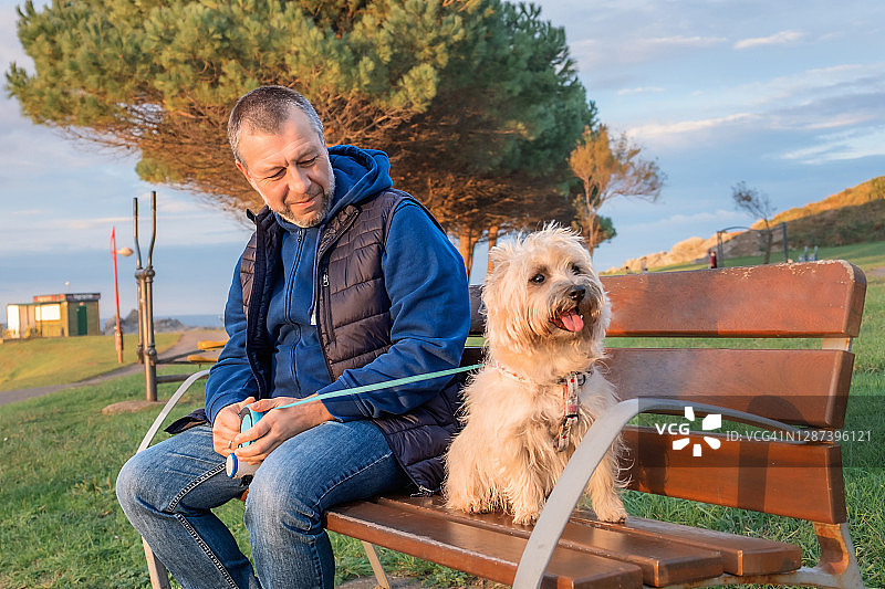 秋日公园里带着狗的男子图片素材