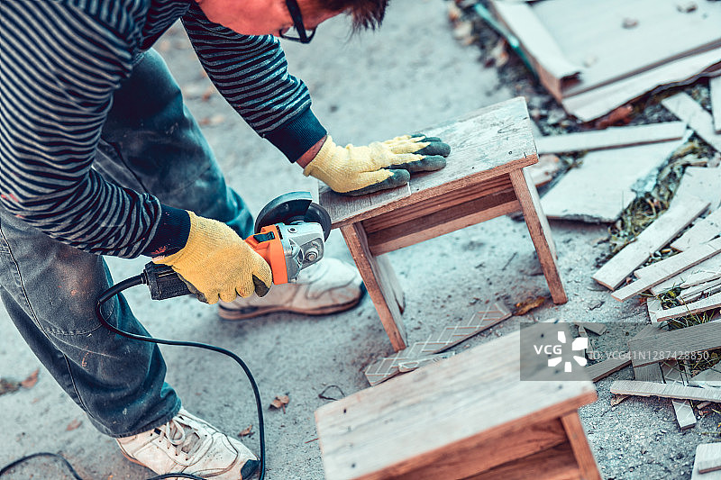 年长工人用圆锯切割地板瓷砖材料图片素材