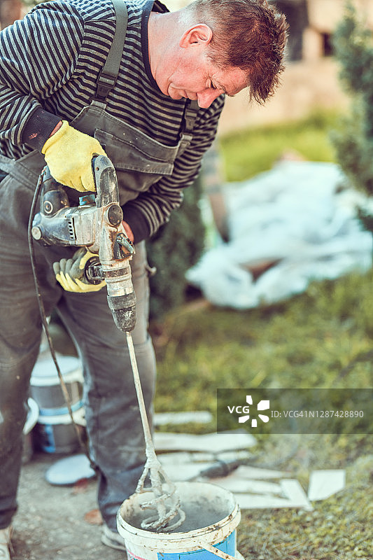 年长的男性工人在搅拌石膏图片素材