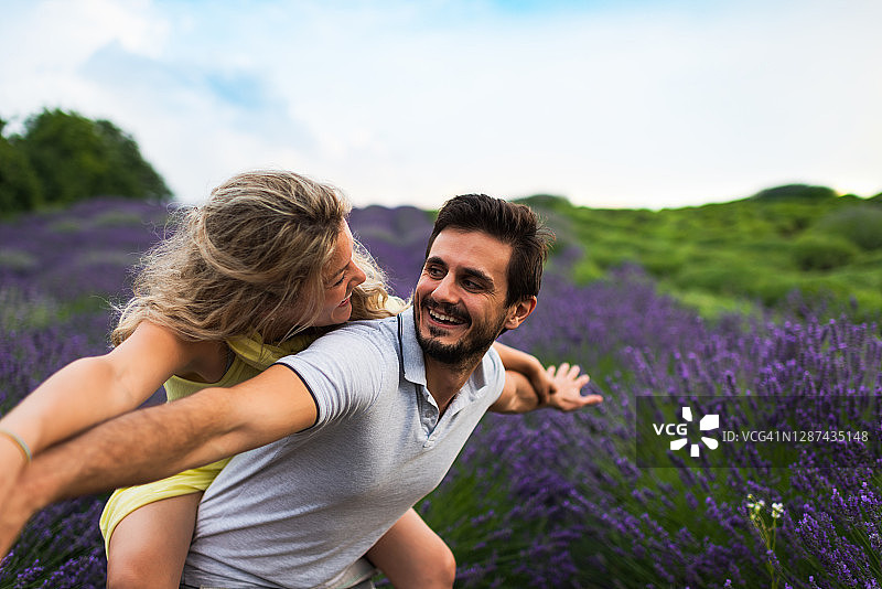 年轻情侣在薰衣草田中享受美好时光图片素材