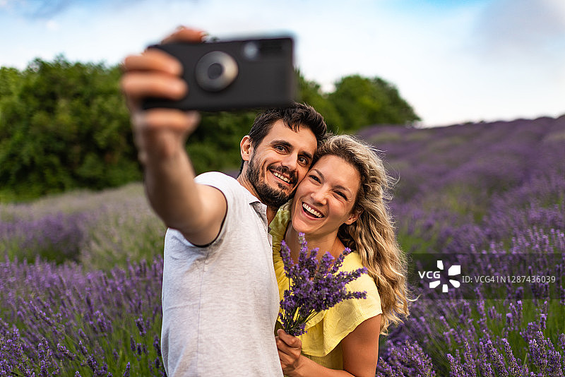 年轻情侣在薰衣草田中享受美好时光图片素材