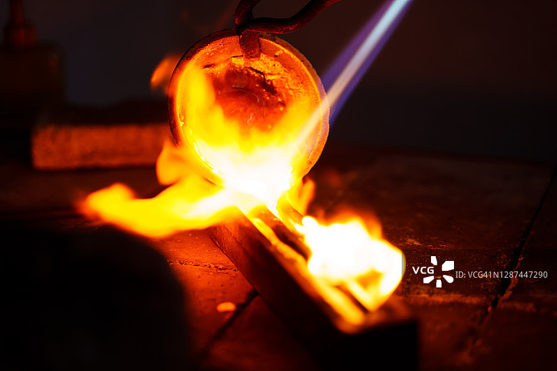 珠宝工坊：喷灯融化的金属倒入模具图片素材