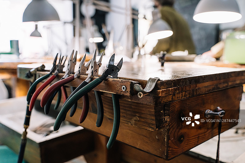 珠宝工作室内挂在古老木桌上的钳子套图图片素材