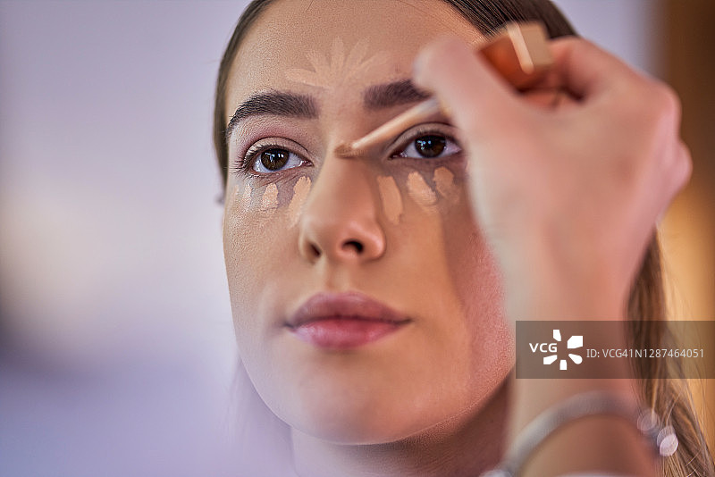专业化妆师使用浅色遮瑕膏为顾客修饰鼻子轮廓图片素材