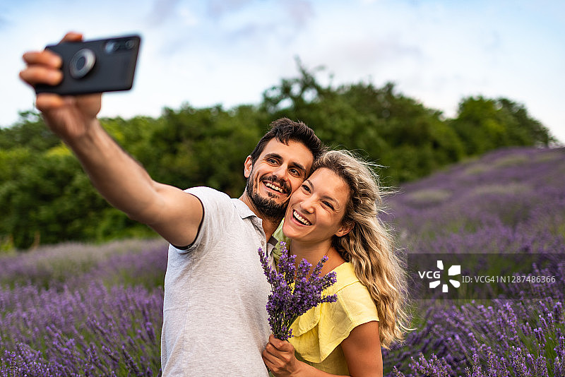 年轻情侣在薰衣草田中享受美好时光图片素材