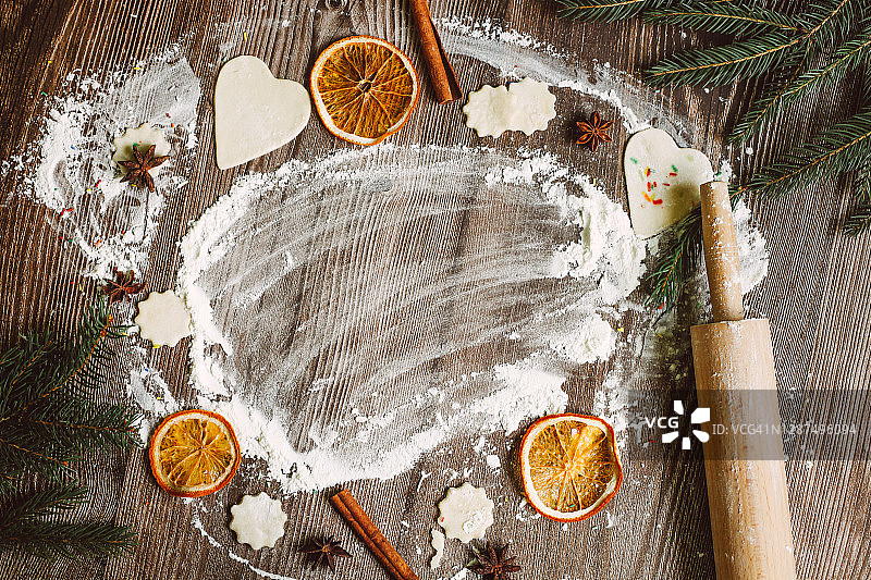 烘焙圣诞饼干的面粉与木桌，含复制空间。面粉、干橙片、肉桂和茴芹冬季香料。图片素材