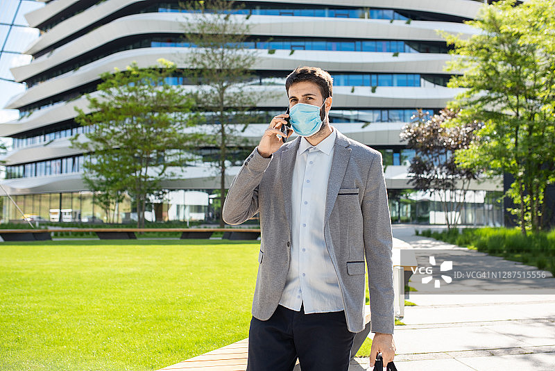 戴着外科口罩以防止城市流感/空气污染的商人图片素材