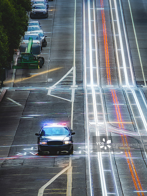 空旷街道上开启警示灯的警车图片素材