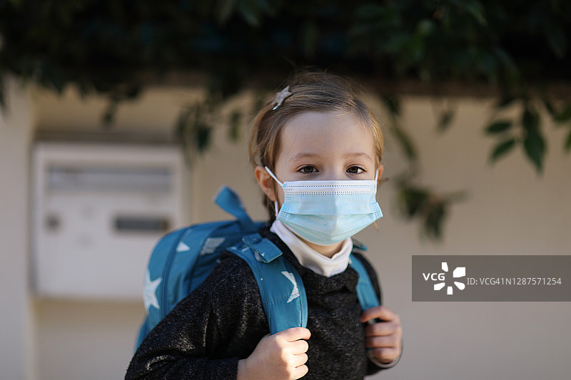戴着防护口罩准备上学的小女孩肖像图片素材