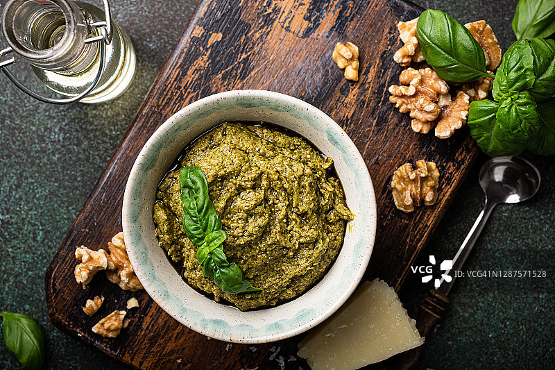 小碗中罗勒青酱、核桃、橄榄油和帕尔马干酪俯视图图片素材