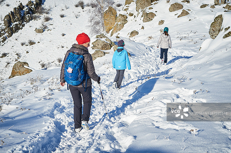 母亲和儿子们在冬季仙境般的山景中图片素材