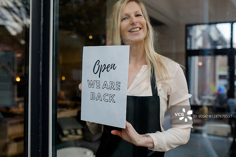 旅店老板/咖啡馆老板很高兴他们的生意可以重新开张图片素材