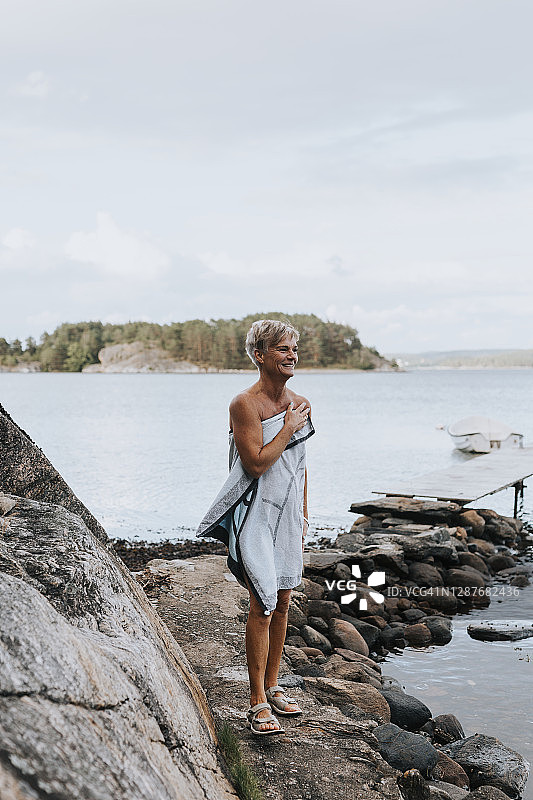 在海边裹着毛巾的微笑女人图片素材