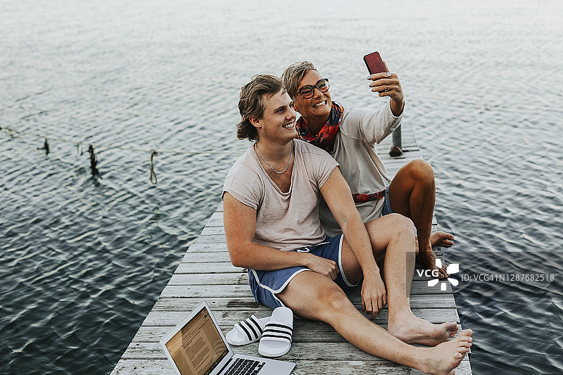 母亲与成年儿子在码头上自拍图片素材