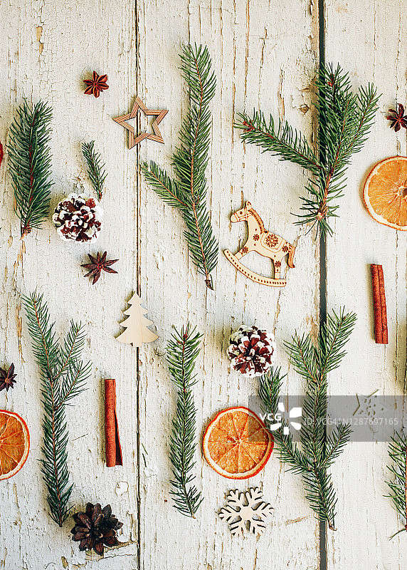 白色木质背景上的竖版节日图案，圣诞松树枝、松果和植物装饰图片素材