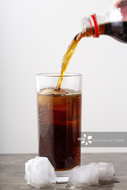 将可乐从瓶子倒入玻璃杯图片素材