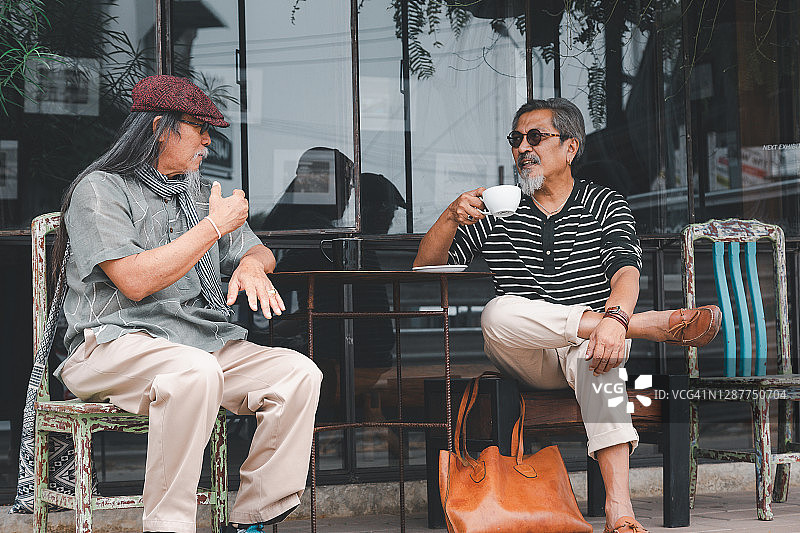 亚洲老年男性朋友在咖啡店喝咖啡聊天图片素材