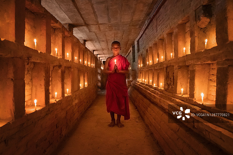烛光寺庙墓缅甸内的佛教沙弥祈祷图片素材