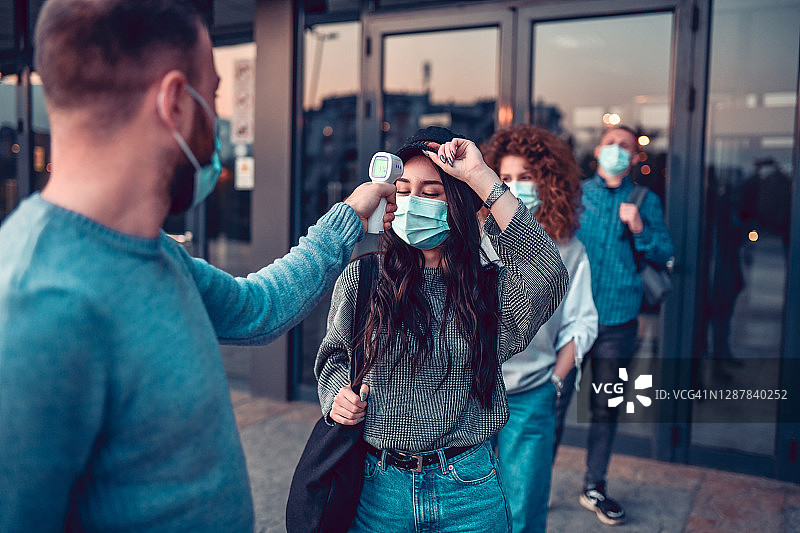 人们离开酒店后测量体温图片素材