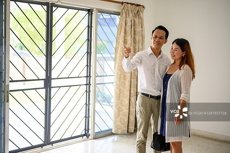 兴奋的亚洲夫妇一起搬进新家图片素材