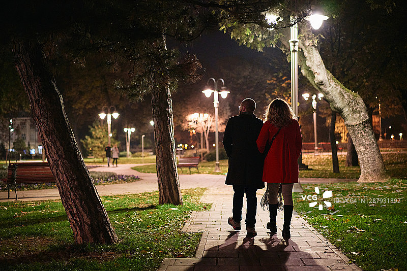在公园享受夜间散步的现代情侣图片素材