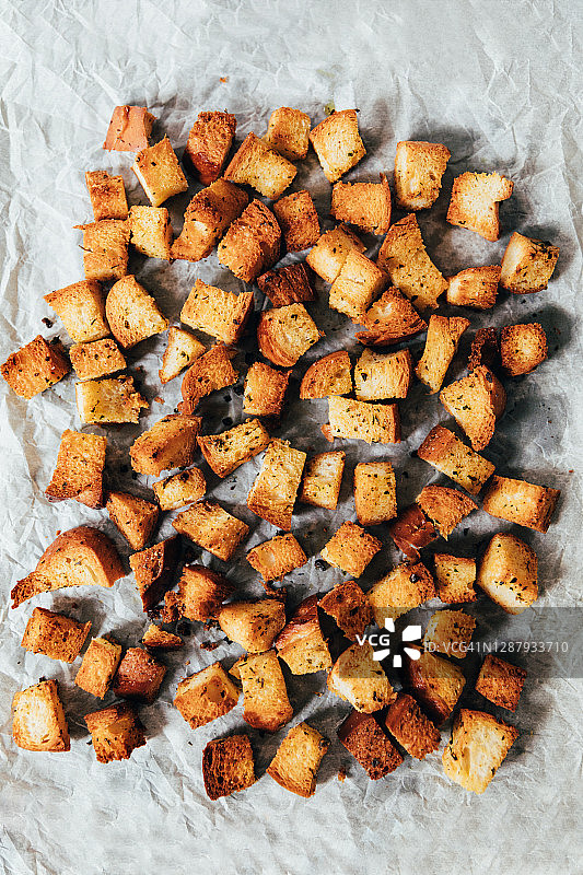 烤纸上烘烤的油炸香草面包丁图片素材