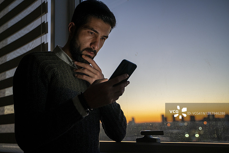 男人看着手机，面露担忧图片素材