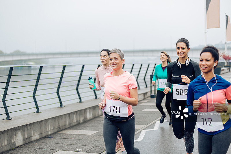 寒冷的一天，多民族妇女参加半程马拉松比赛图片素材
