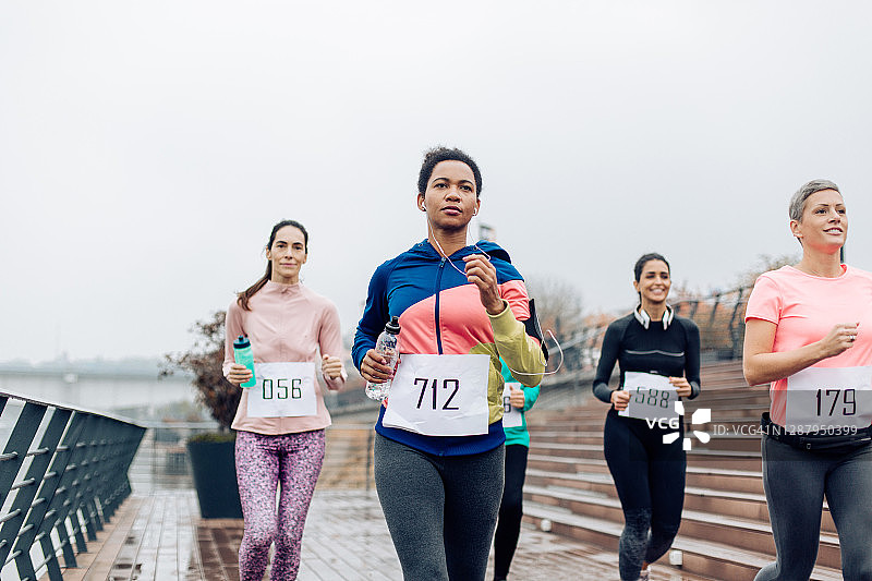 在雨天参加比赛的女性马拉松赛跑者图片素材