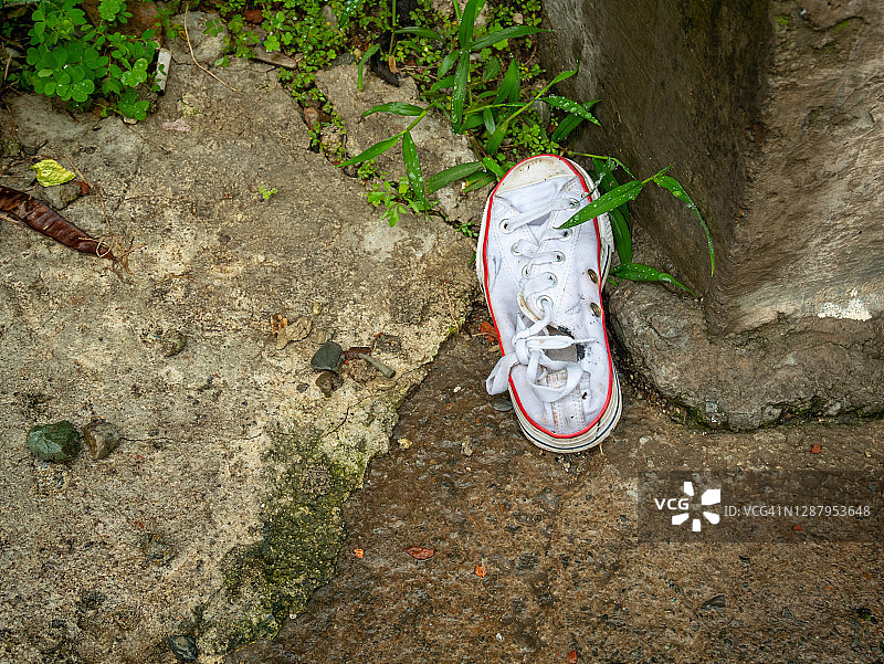 躺在街上的旧白色运动鞋图片素材
