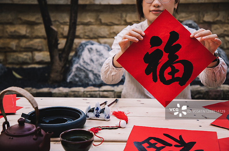 亚洲女性手持汉字“福”字书法，寓意新年好运图片素材