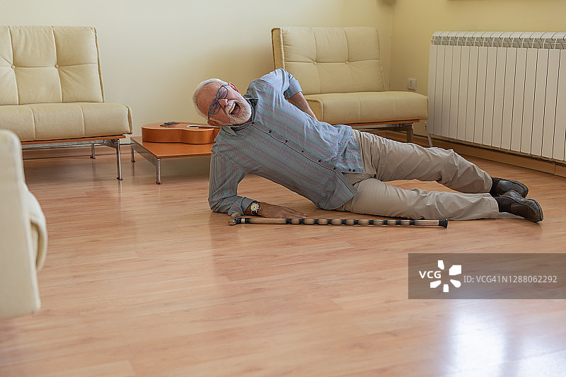 一位身有残疾的老人摔倒在客厅地板上图片素材