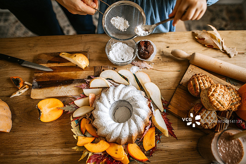 小女孩在蛋糕上撒糖粉图片素材