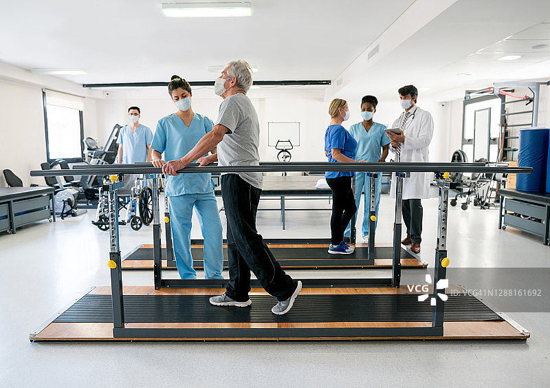 理疗中心的一群医生和戴着口罩的患者图片素材