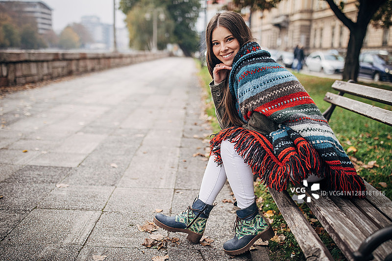 坐在城市长椅上的现代女性图片素材