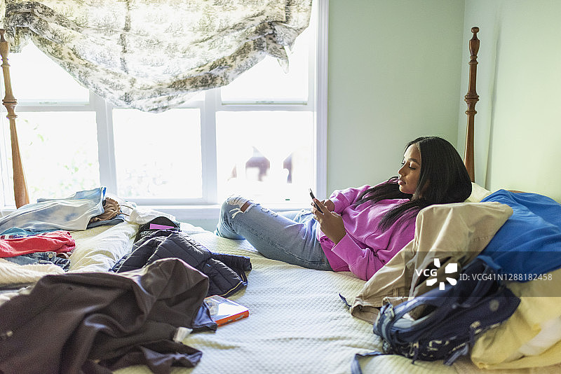 年轻女人在床上玩手机图片素材