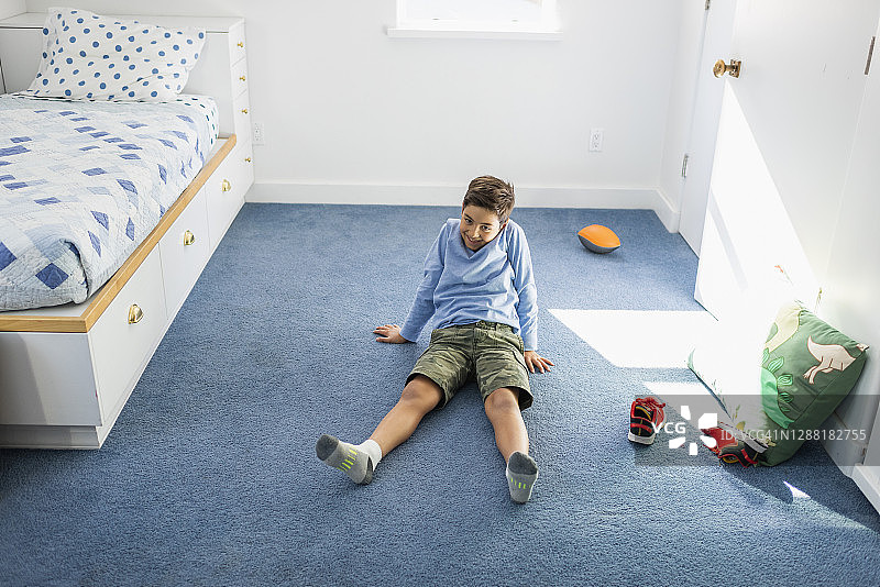 男孩在卧室的地板上图片素材