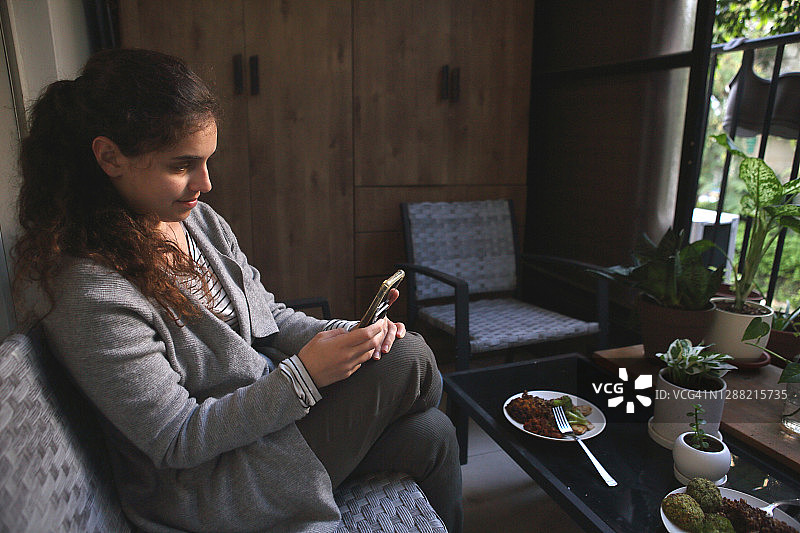 午休期间玩手机的女学生图片素材