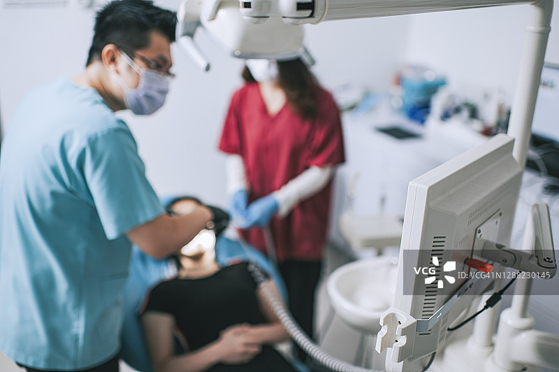 中国牙医在诊所为患者做手术，护士协助图片素材