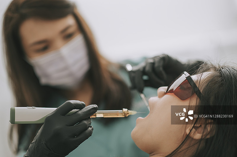 亚裔女牙医为病人注射图片素材