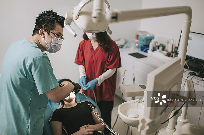 中国牙医在诊所为患者做手术，护士协助图片素材