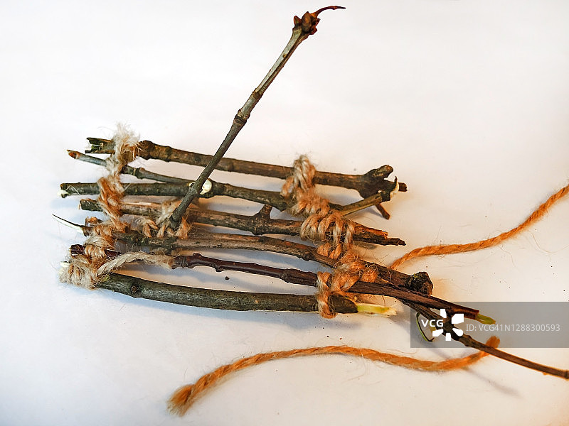 儿童手工艺品：细树枝与细绳木筏特写图片素材