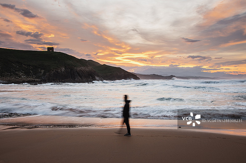 日落时分的海滩，有人在行走图片素材