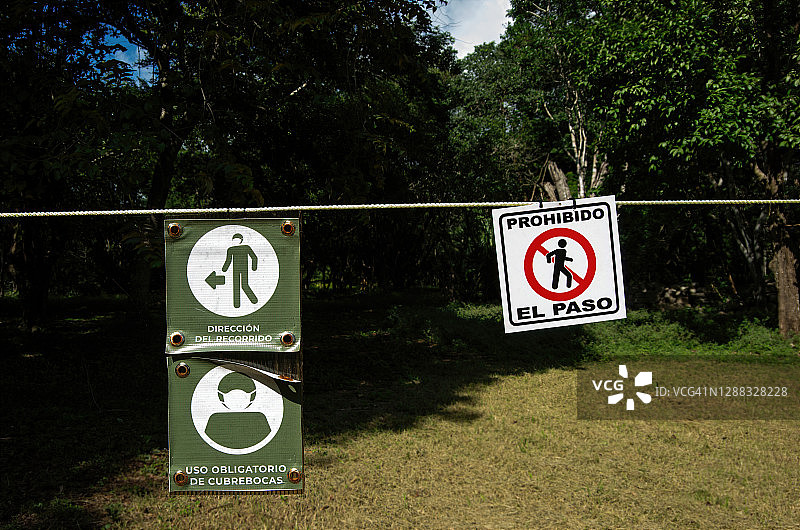 墨西哥尤卡坦乌斯马尔遗址的西班牙语新冠疫情健康安全标牌和隔离带图片素材