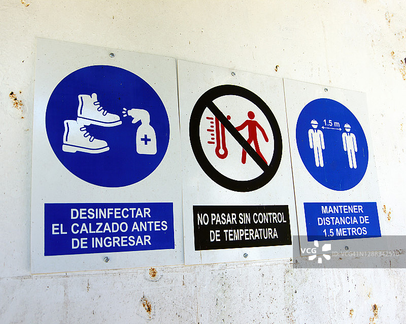 工地外墙上的西班牙语新冠肺炎健康安全标志图片素材