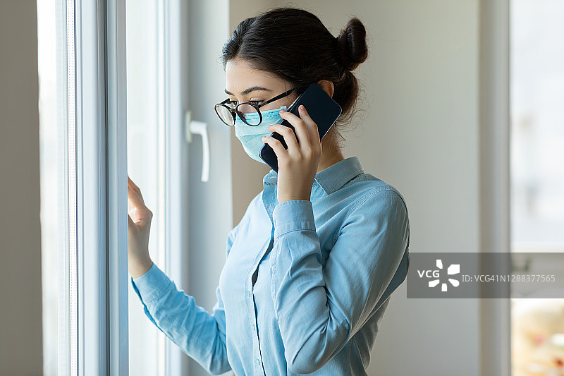 新冠疫情期间居家隔离的打电话的女人图片素材
