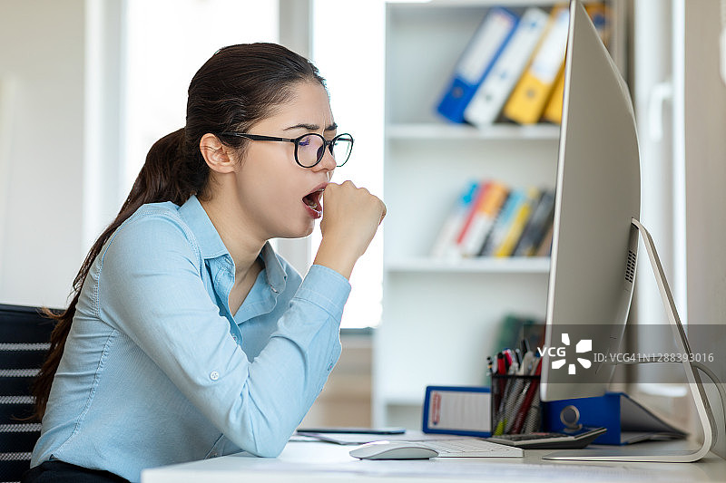 工作场所打哈欠的疲惫女商人图片素材